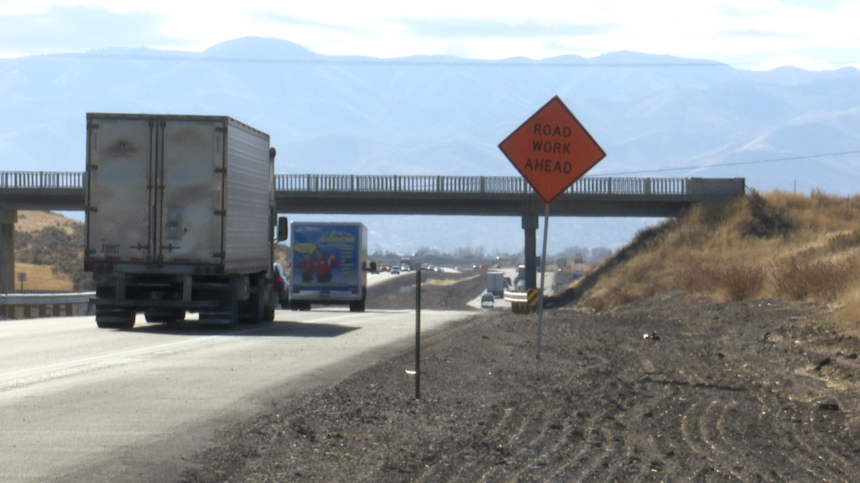 Trucks travel on I-15 near active construction.